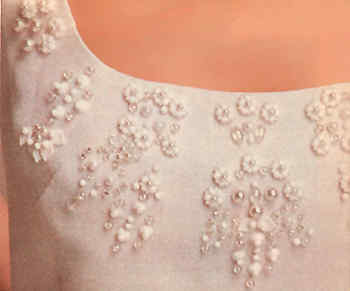 Dekolleté eines weißen perlenbestickten Kleides